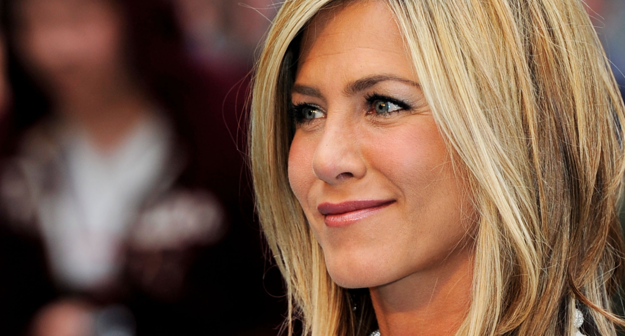 close up of jennifer aniston with blond hair on red carpet with blurred background 