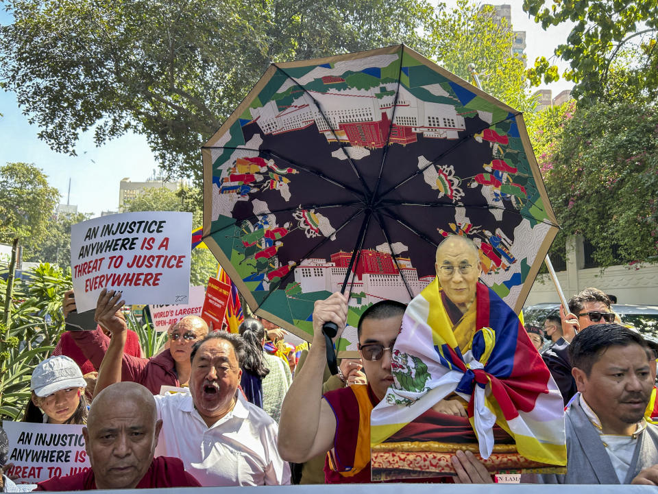 An exile Tibetan carries a cutout of their spiritual leader the Dalai Lama during a rally to mark the anniversary of the 1959 Tibetan uprising in Lhasa, in New Delhi, India, Sunday, March 10, 2024. Hundreds of Tibetans in exile marched on the New Delhi streets on Sunday to commemorate the 65th Tibetan National Uprising Day against China to honor the Tibetan martyrs and express concern over the appalling situation in Tibet. (AP Photo/Shonal Ganguly)