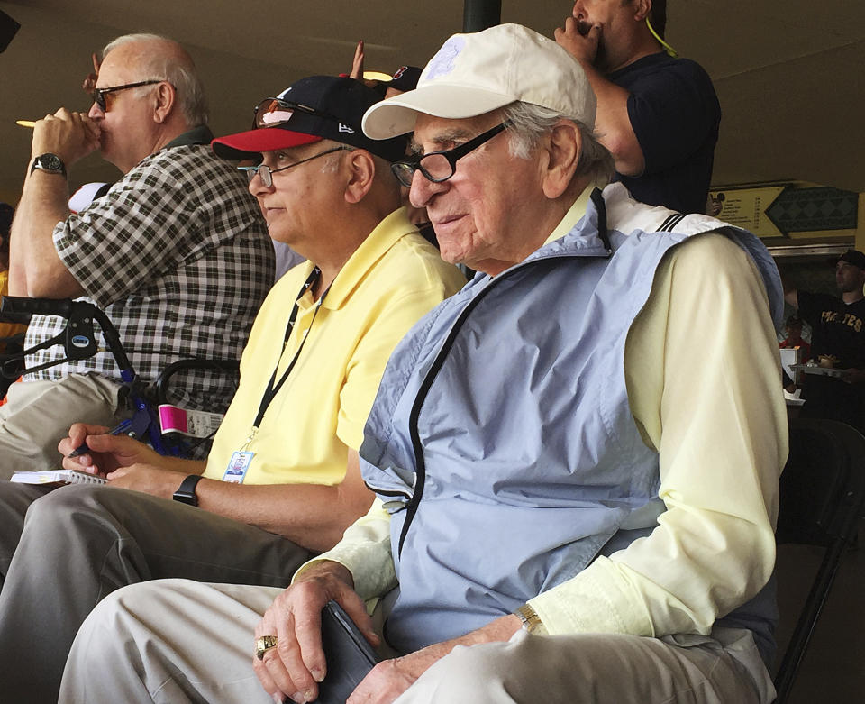 FILE - In this March 5, 2016, file photo, Tommy Giordano, right, special assistant to the general manager of the Atlanta Braves, scouts a spring training baseball game between the Braves and the Pittsburgh Pirates in Kissimmee, Fla. Giordano spent nearly all of his marvelously full life as a baseball man. He’s going out like he lived for more than 93 years _ surrounded by family and friends, accompanied by overwhelming love and stories that will endure long after he’s gone. (AP Photo/Paul Newberry, File)