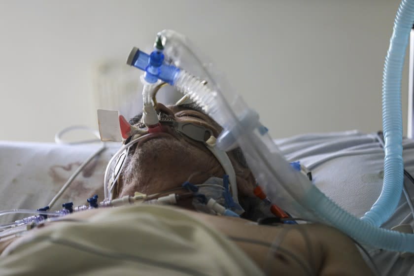 NATIONAL CITY, CA - JULY 08: Coronavirus patient Pedro Luera, 68, breaths through a ventilator at Paradise Valley Hospital, National City. Pedro's wife Patricia is also a coronavirus patient is being treated in the same unit of the hospital. Both were transported from El Centro via Mercy Air ambulances to Paradise Valley Hospital. (Irfan Khan / Los Angeles Times)