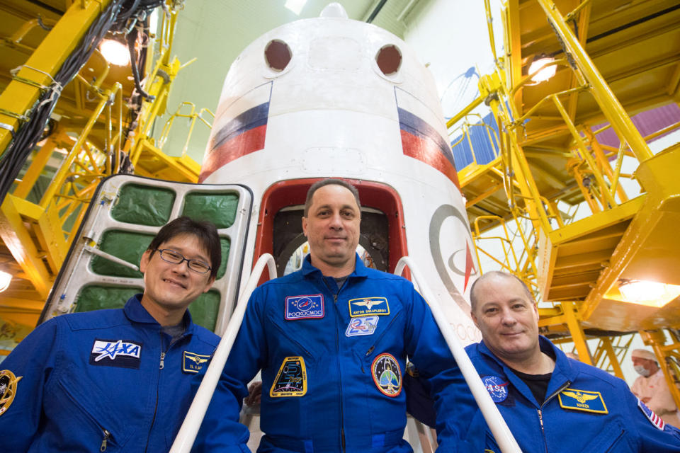 jsc2017e138117 - At the Integration Facility at the Baikonur Cosmodrome in Kazakhstan, the Expedition 54-55 prime crewmembers pose for pictures Dec. 13 in front of the Soyuz MS-07 spacecraft during pre-launch training. Norishige Kanai of the Japan Aerospace Exploration Agency (JAXA), Anton Shkaplerov of the Russian Federal Space Agency (Roscosmos, center) and Scott Tingle of NASA (right) will launch Dec. 17 on the Soyuz MS-07 vehicle for a five month mission on the International Space Station...Andrey Shelepin/Gagarin Cosmonaut Training Center.