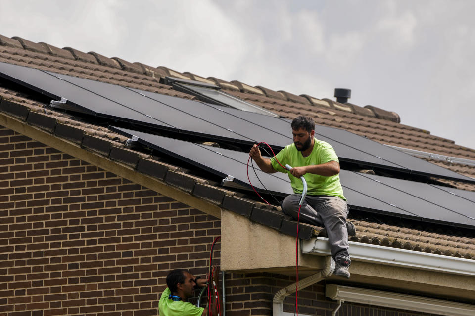 Workers install solar planers on the roof of a house in Rivas Vaciamadrid, Spain, Thursday, Sept. 15, 2022. The energy crisis is accelerating the installation of solar panels by residential communities in Spain who want to become self-sufficient. Recent legislation has allowed so-called "energy communities" to generate renewable power through collective installations. (AP Photo/Manu Fernandez)