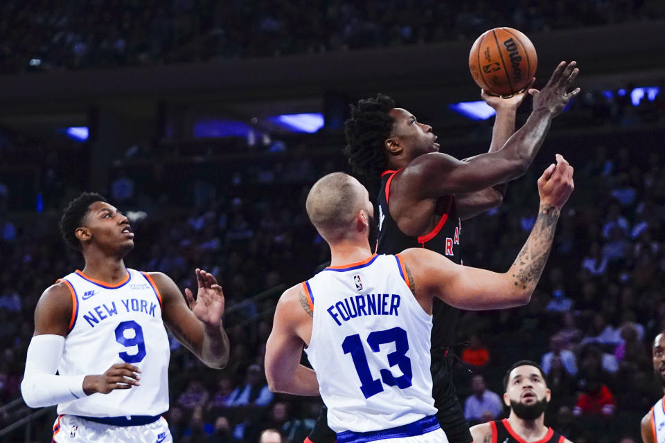 Toronto Raptors' OG Anunoby, right, drives past New York Knicks' Evan Fournier (13) and RJ Barrett (9) during the first half of an NBA basketball game Monday, Nov. 1, 2021, in New York. (AP Photo/Frank Franklin II)