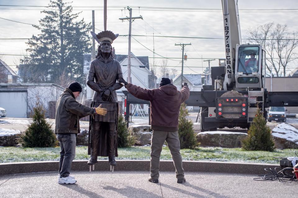 Alan Cottrill (right) guides his bronxe statue of Chief Netawatwees into place with the help of Josh Becker (left). The Lenape Diaspora Memorial will highlight six figures related to Cottrill of the Lenape tribe of Native Americans, who settled in the area.
