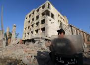 A security official guards the site of a bomb blast at a state security building in Shubra Al-Khaima, on the outskirts of Cairo, August 20, 2015. Islamic State's Egypt affiliate said it was behind a car bombing that wounded 29 people near a state security building and courthouse in a Cairo suburb early on Thursday. (REUTERS/Mohamed Abd El Ghany)