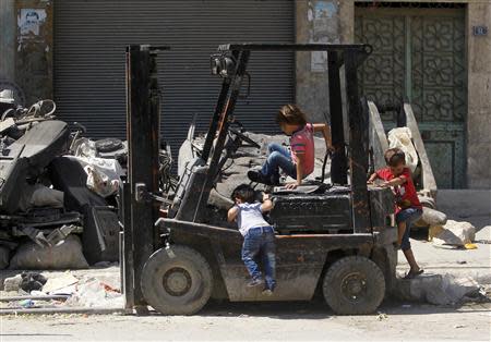 Children play on a forklift in Aleppo September 9, 2013. REUTERS/Muzaffar Salman
