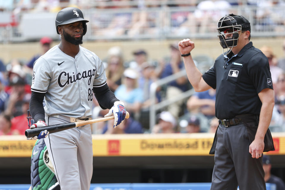 Chicago White Sox's Luis Robert Jr., left, reacts after striking out against the Minnesota Twins during the first inning of a baseball game, Sunday, Aug. 4, 2024, in Minneapolis. (AP Photo/Matt Krohn)