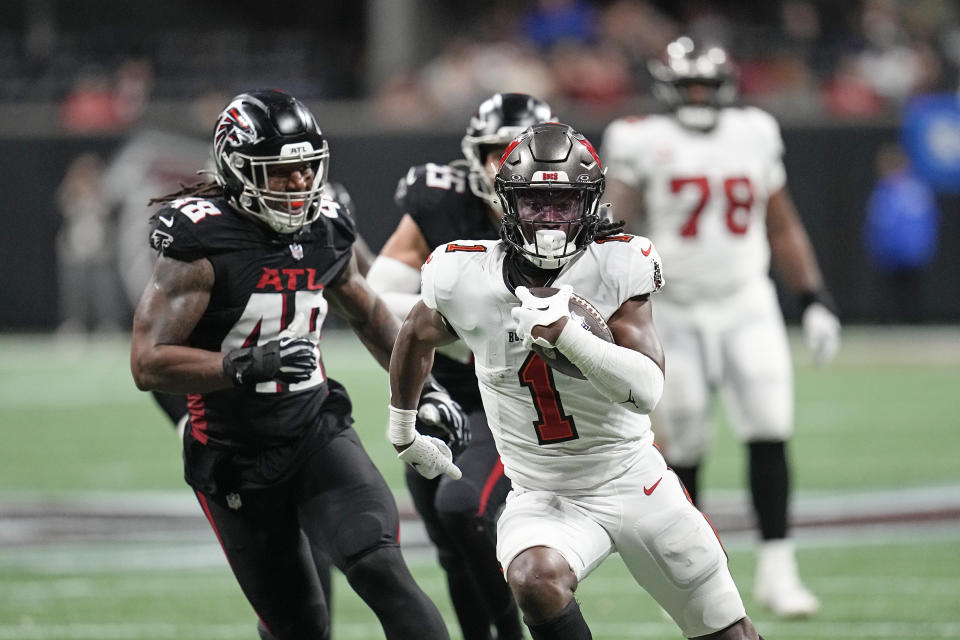 Tampa Bay Buccaneers running back Rachaad White (1) runs for a touchdown as Atlanta Falcons linebacker Bud Dupree (48) gives chase during the second half of an NFL football game, Sunday, Dec. 10, 2023, in Atlanta. (AP Photo/Mike Stewart)