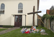 Floral tributes laid in front of a cross erected outside Chinnor Community Church in Chinnor, Oxfordshire, in memory of Zoe Powell, 29, and her three children - Phoebe, eight, Simeon, six, and Amelia, four - who were killed in a car accident on the A40 near Oxford on Monday night.