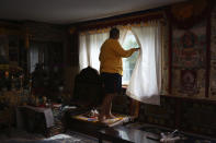 Jalue Dorje, 14, looks out the window for his father as they clean up after a weekend of ceremonies paying homage to Guru Rinpoche, the Indian Buddhist master who brought Tantric Buddhism to Tibet, on Tuesday, July 20, 2021, in Columbia Heights, Minn. (AP Photo/Jessie Wardarski)