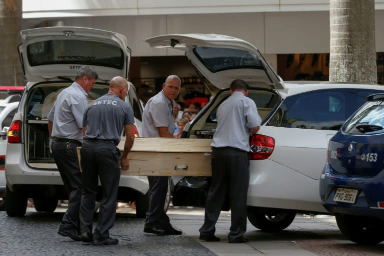 Municipal workers remove bodies from the cathedral. Brazil is one of the most violent countries in the world