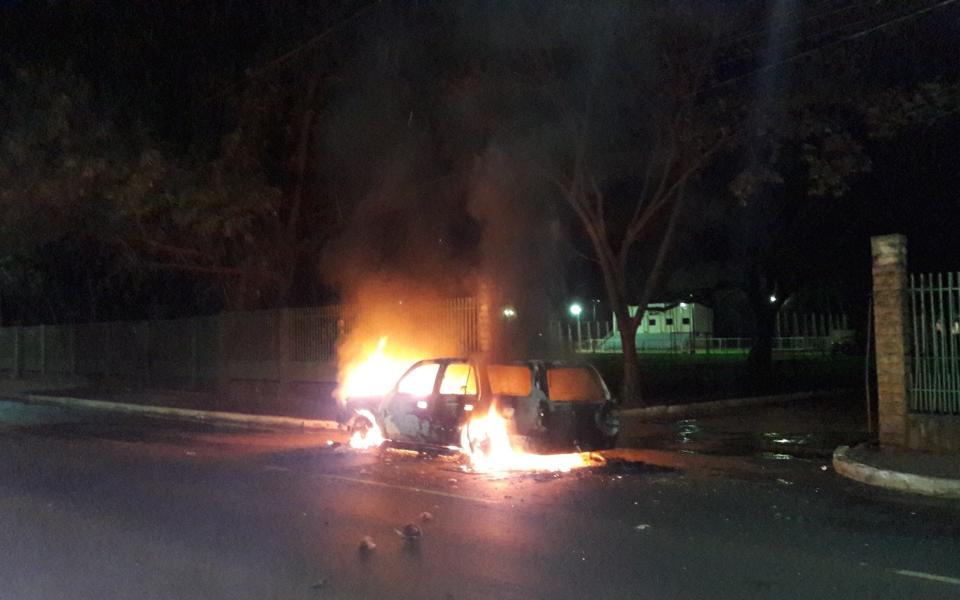 A vehicle burns after thieves set it on fire during their escape in Ciudad del Este, Paraguay - Credit: AP