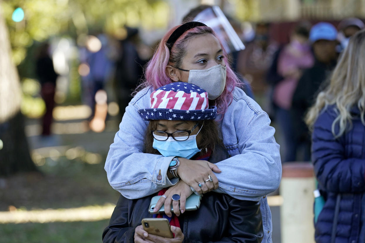 Erin Doherty hugs her mother Susanna Dew, 61, who is voting for the first time, as they wait in line at a polling place on Election Day in the Mid City section of New Orleans on Nov. 3, 2020. (Gerald Herbert/AP)