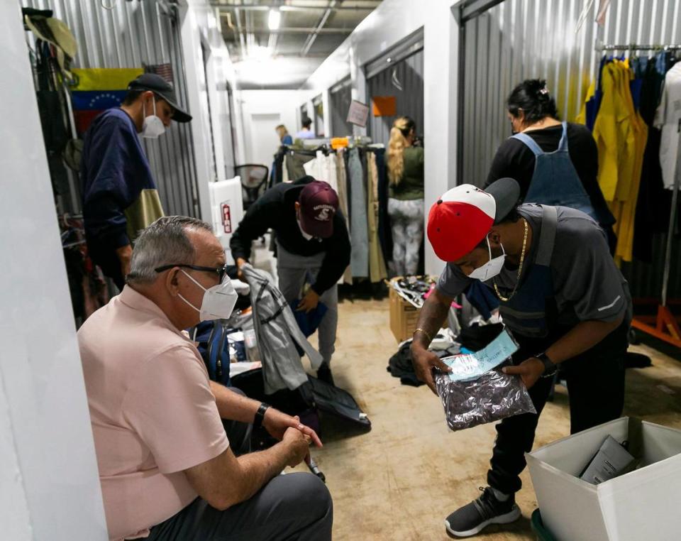 Héctor Luis Romero Meza, de 31 años (der.), mira la ropa en Raíces Venezolanas en Miami, Florida, el viernes 8 de abril de 2022. La organización sin fines de lucro ayuda a los inmigrantes que llegan al sur Florida de Venezuela con ropa, zapatos y artículos para el hogar gratis.