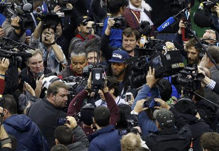 Seattle Seahawks cornerback Richard Sherman is surrounded by cameras as he arrives during Media Day for Super Bowl XLVIII at the Prudential Center in Newark, New Jersey January 28, 2014. REUTERS/Carlo Allegri