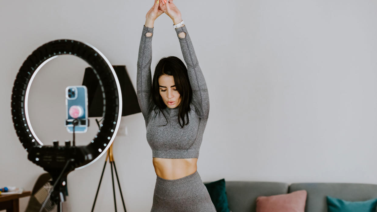  Fitness influencer working out in front of a camera 