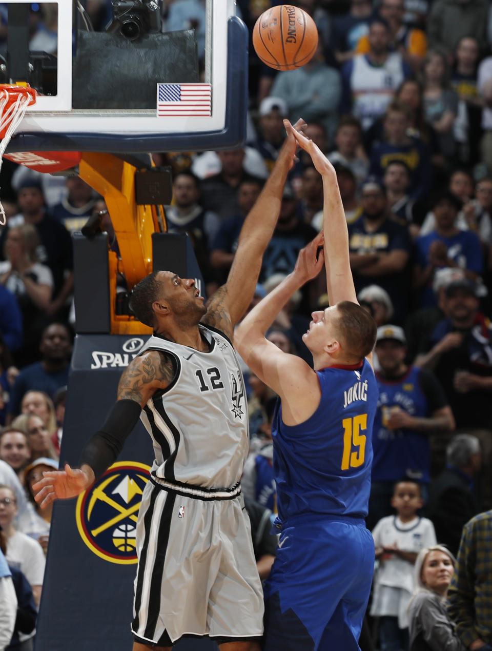 Denver Nuggets center Nikola Jokic (15) shoots over San Antonio Spurs center LaMarcus Aldridge (12) in the first half of Game 5 of an NBA basketball first round playoff series, Tuesday, April 23, 2019, in Denver. (AP Photo/David Zalubowski)