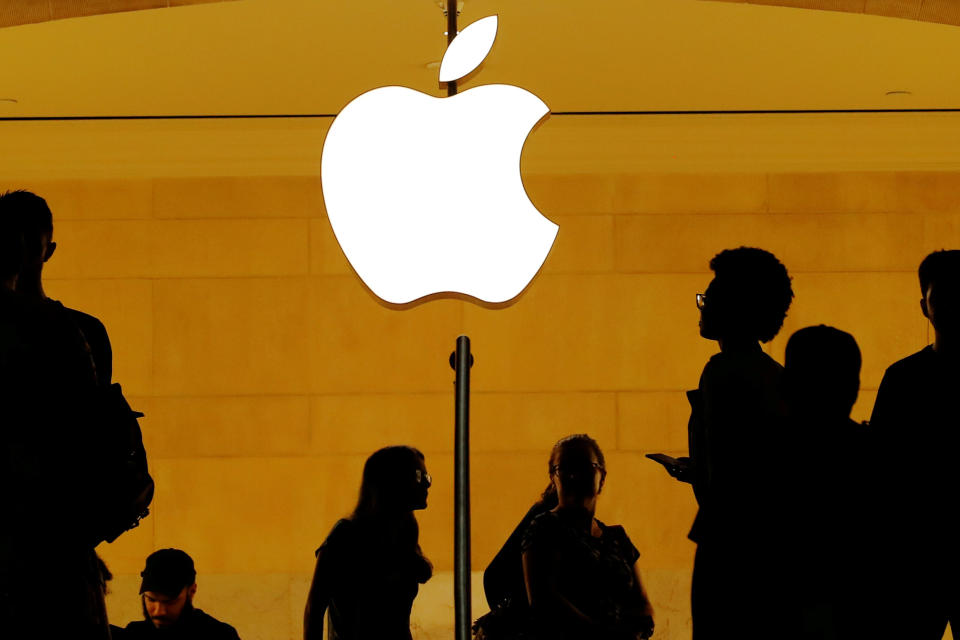 Customers walk past an Apple logo inside of an Apple store at Grand Central Station in New York. REUTERS/Lucas Jackson/File Photo