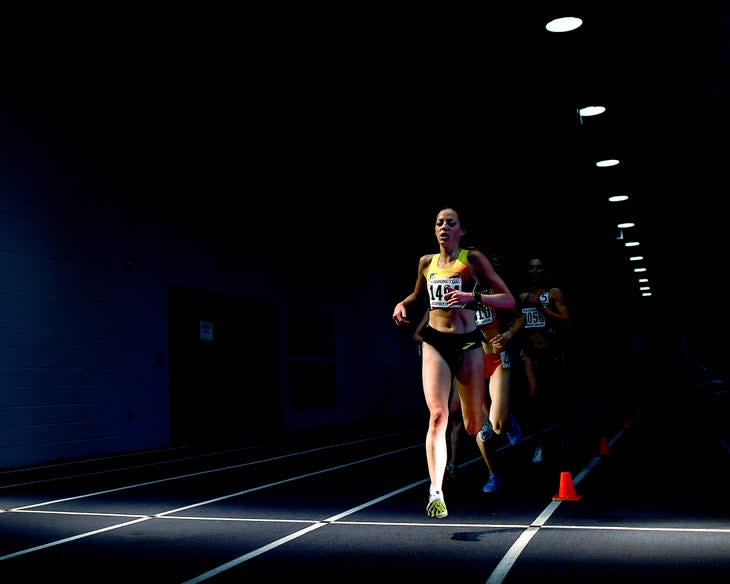 Natosha Rogers runs on dark track