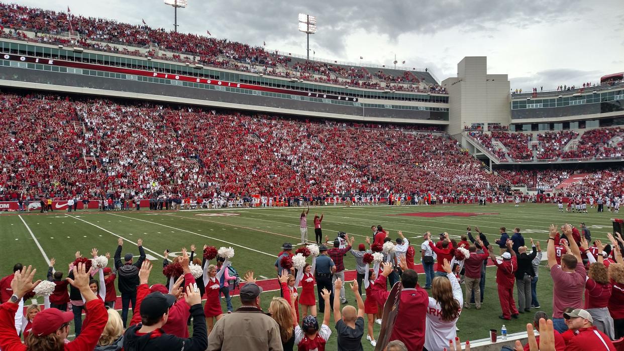 Madre Hill leads a hog call in Razorback stadium.