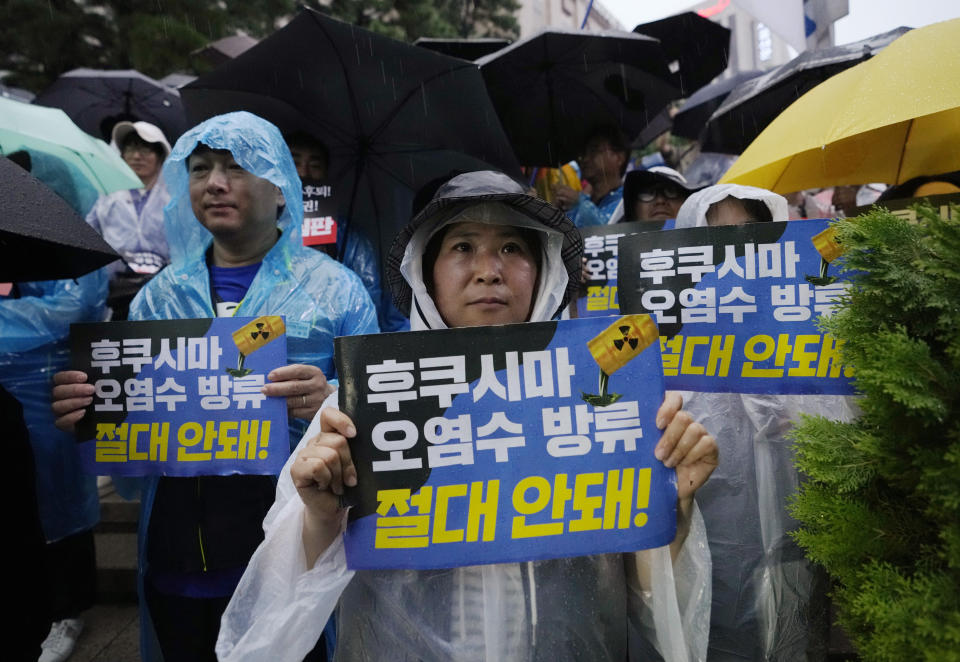 Protesters attend a rally against the Japanese government's decision to release treated radioactive wastewater from the damaged Fukushima nuclear power plant, in Seoul, South Korea, Tuesday, July 4, 2023. The head of the U.N. nuclear agency is in Japan to meet with government leaders Tuesday and to see final preparations for the release of treated radioactive wastewater into the sea from the damaged Fukushima nuclear plant, on a visit Japan hopes will give credibility to the contentious plan. The letters read "Oppose to release treated radioactive water from the Fukushima." (AP Photo/Ahn Young-joon)