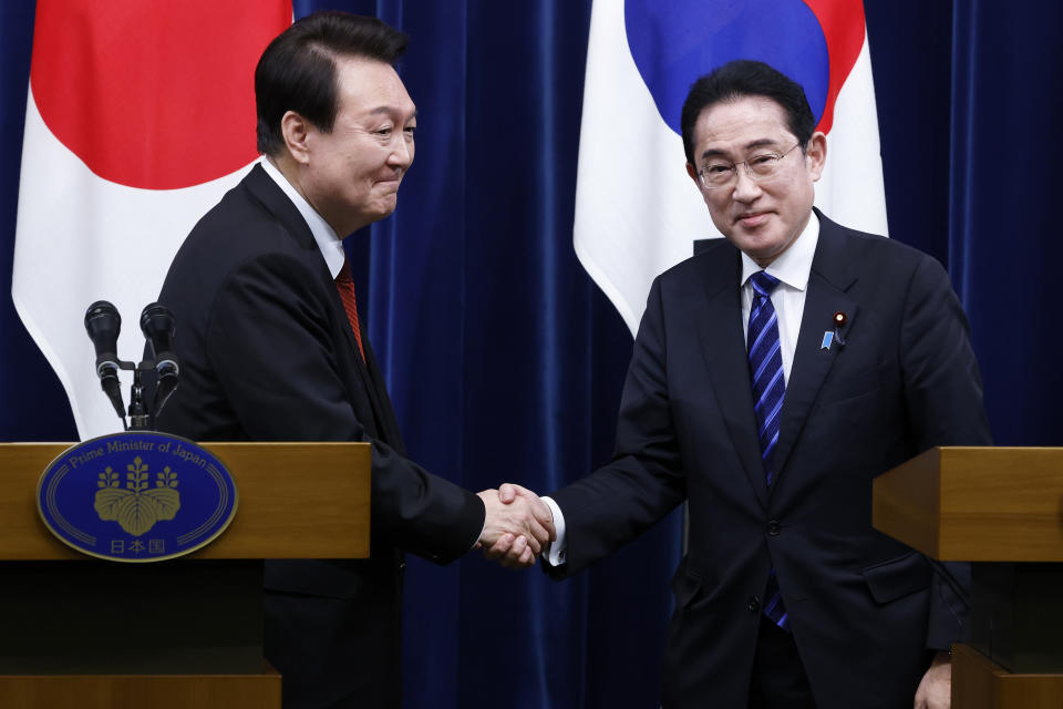 South Korean President Yoon Suk Yeol, left, and Japanese Prime Minister Fumio Kishida, right, shake hands following a joint news conference at the prime minister's official residence in Tokyo, Japan, Thursday, March 16, 2023. (Kiyoshi Ota/Pool Photo via AP)