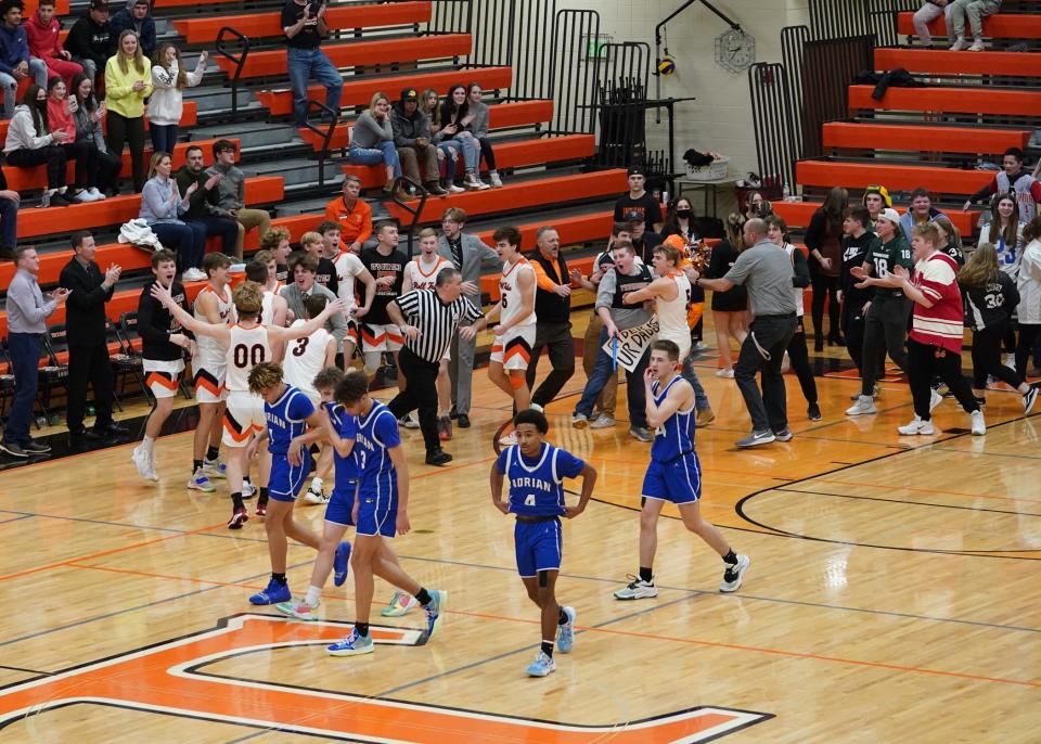 The Tecumseh boys basketball team celebrates with the student section as Adrian walks off the floor following Friday's game in Tecumseh.