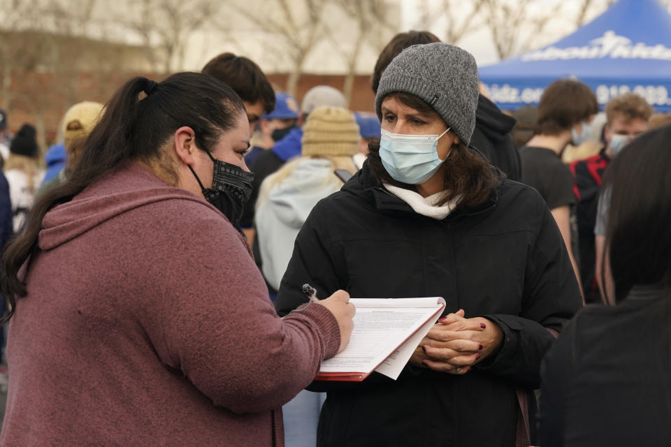 Susan Ortega, right, gathers signatures on a petition to recall Gov. Gavin Newsom at a "Let Them Play" rally calling for Newsom to allow the state's school children to participate in sports, held in Citrus Heights, Calif., Friday, Jan. 29., 2021. In his efforts to get California schoolchildren back in classrooms, Newsom has met with roadblocks from school superintendents and the the country's most powerful teacher's unions.(AP Photo/Rich Pedroncelli)