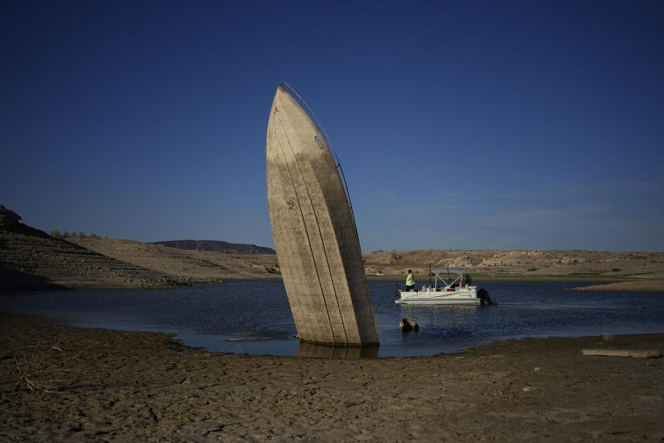 FILE - A formerly sunken boat sits upright into the air with its stern stuck in the mud along the shoreline of Lake Mead at the Lake Mead National Recreation Area, June 10, 2022, near Boulder City, Nev. In November 1922, seven land-owning white men brokered a deal to allocate water from the Colorado River, which winds through the West and ends in Mexico. During the past two decades, pressure has intensified on the river as the driest 22-year stretch in the past 1,200 years has gripped the southwestern U.S. (AP Photo/John Locher, File)