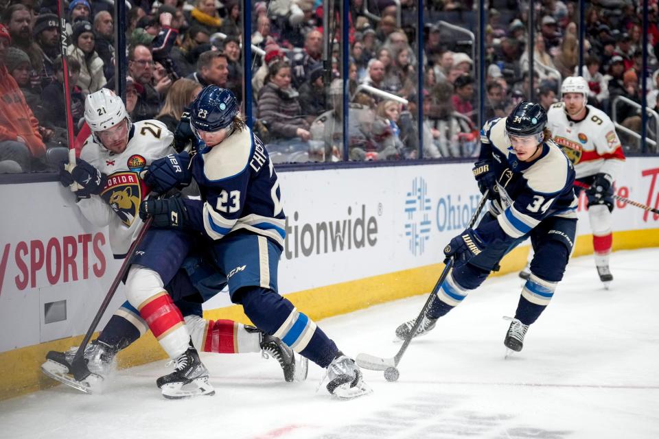 Nov 20, 2022; Columbus, Ohio, United States;  Columbus Blue Jackets forward Cole Sillinger (34) skates away with the puck after defenseman Jack Christiansen (23) and Florida Panthers forward Nick Cousins (21) collide with the side of the rink during the second period of the NHL hockey game at Nationwide Arena. Mandatory Credit: Joseph Scheller-The Columbus Dispatch