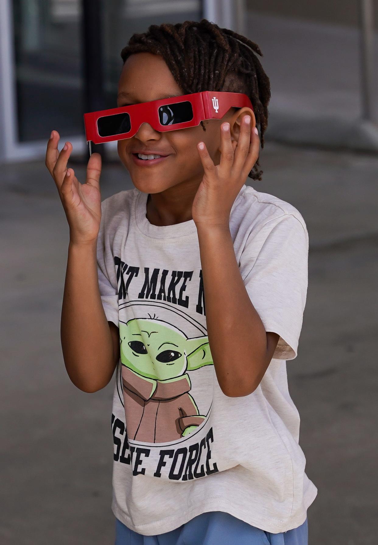 Prince Wilmot of Avon, Indiana, checks out his eclipse glasses during the Hoosier Cosmic Celebration on Monday, April 8, 2024.