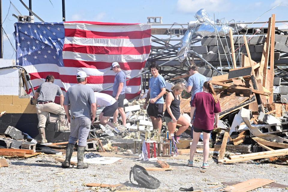 Amory varsity basketball players sort through belongings at at the high school athletic facility in Amory after an overnight tornado caused widespread damage.