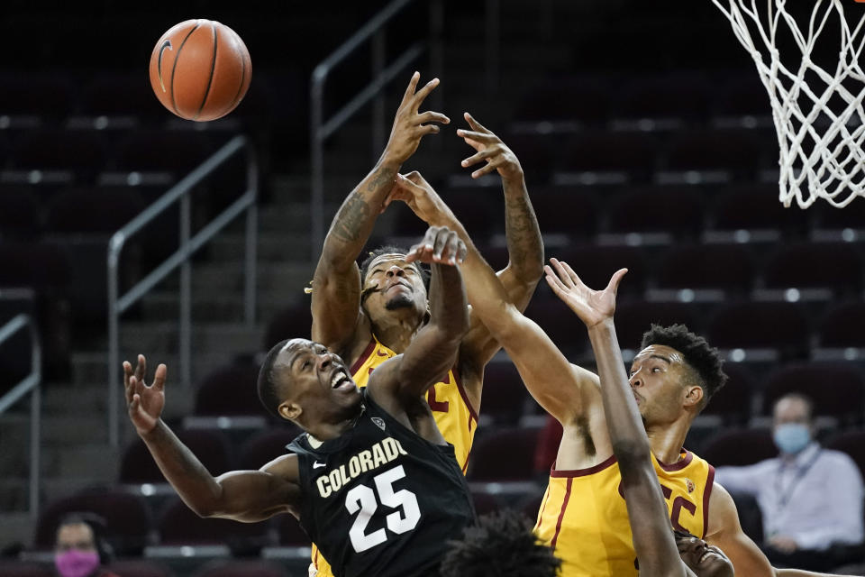 Colorado's McKinley Wright IV, bottom left, is defended by Southern California's Isaiah Mobley, right, and Isaiah White during the second half of an NCAA college basketball game Thursday, Dec. 31, 2020, in Los Angeles. Colorado won 72-62. (AP Photo/Jae C. Hong)