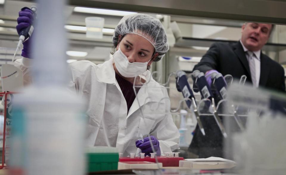 In this April 15, 2014 photo, Mark Desire, right, assistant director for forensic biology at the Office of Chief Medical Examiner, speaks as a criminalist, training in forensic science, prepares sample bone fragments for DNA testing at the training lab, in New York. With new technology yielding results impossible a dozen years ago, forensic scientists are still trying to match the bone with DNA from those who died on Sept. 11, 2001, and have never been identified. (AP Photo/Bebeto Matthews)