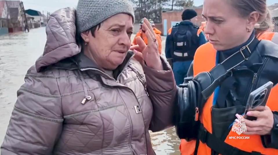 In this grab taken from a video released by the Russian Emergency Ministry Press Service on Saturday, April 6, 2024, a Russian Emergency Ministry worker comforts an elderly woman during evacuation after a part of a dam burst causing flooding, in Orsk, Russia. Floods hit a city in the Ural Mountains areas after a river dam burst there, prompting evacuations of hundreds of people, local authorities said. The dam breach in Orsk, a city less than 20 kilometers north of Russia’s border with Kazakhstan, occurred on Friday night, according to Orsk mayor Vasily Kozupitsa. (Russian Emergency Ministry Press Service via AP)