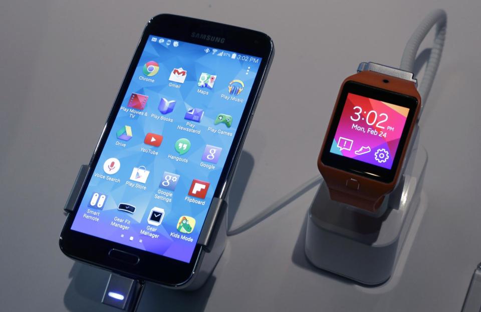 A Samsung Galaxy S5 smartphone, left, and a Samsung Gear 2 are displayed at the Samsung Galaxy Studio, in New York, Monday, Feb. 24, 2014. Samsung on Monday unveiled a new smartphone with a built-in heart rate monitor to complement three upcoming fitness devices, as the Korean company tries to turn its technological wizardry into lifestyle products. (AP Photo/Richard Drew)