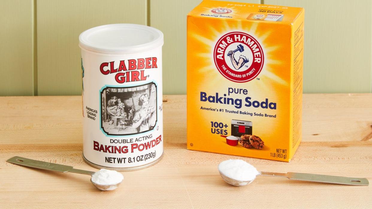 a can of baking powder and a box of baking soda on a table