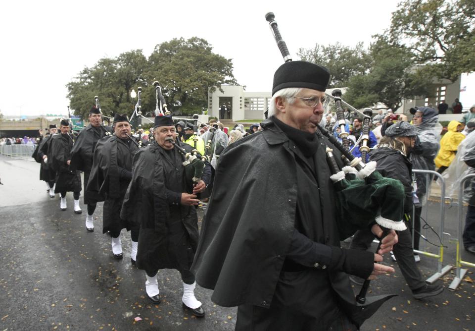 The Dallas Metro Police Pipes and Drums corps march up Elm Street during ceremonies marking the 50th anniversary of JFK's assassination in Dallas