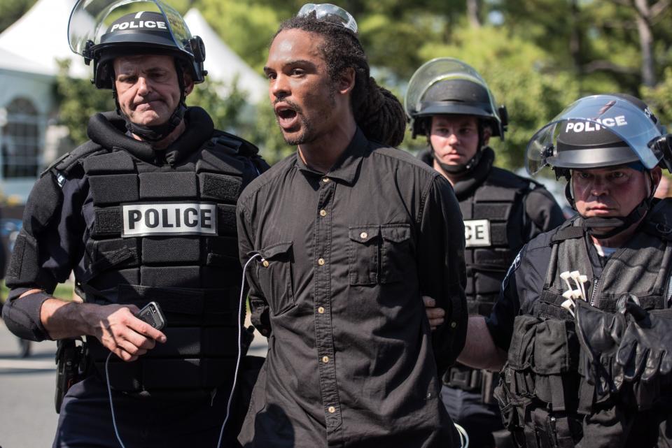 <p>Police in riot gear detain a demonstrator outside of Bank of America Stadium before an NFL football game between the Charlotte Panthers and the Minnesota Vikings September 25, 2016 in Charlotte, North Carolina. Protests have disrupted the city since Tuesday night following the shooting of 43-year-old Keith Lamont Scott at an apartment complex near UNC Charlotte. (Photo by Sean Rayford/Getty Images) </p>