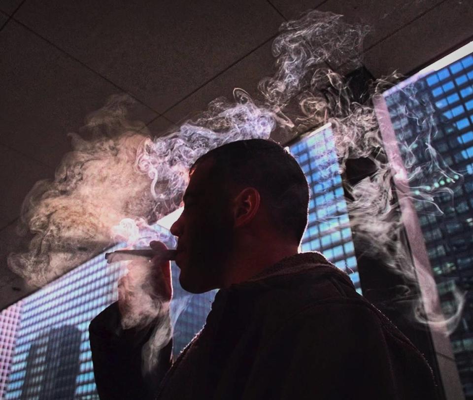 Smoke swirls around a cigar smoker in Chicago. Visualize how smoke moves and lingers to better understand how coronavirus-laden aerosols emitted from the mouth can be inhaled by surrounding people, says a scientist studying infectious disease transmission.