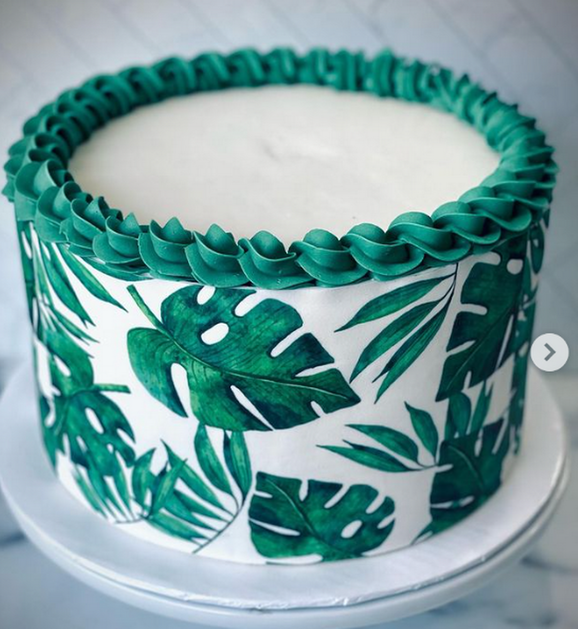 Tropical leaves themed chocolate cake for a luau graduation party by Simply Sweetz LLC, with (not pictured) pineapple cupcakes to match. Courtesy: @simplysweetz_llc Instagram