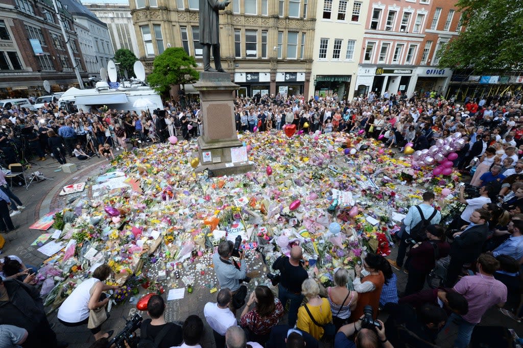 Crowds look at the floral tributes after a minute’s silence in St Ann’s Square, Manchester, to remember the victims of the terror attack in 2017 (Ben Birchall/PA) (PA Archive)