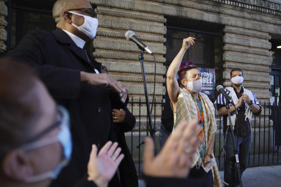 Shira Kline, a director of worship for Lab/Shul, a Jewish community-based organization, leads a group in song during an interfaith gathering outside of the Judson Memorial Church near Washington Square Park in New York, Wednesday, Nov. 4, 2020. Muslims, Jews, Christians and Buddhists came together to show solidarity among faith communities as the country awaits the final result of the U.S. presidential election. (AP Photo/Emily Leshner)