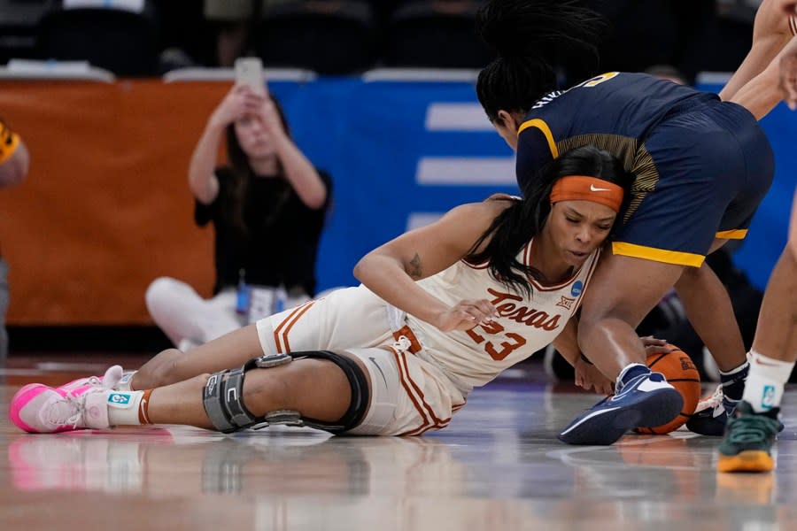 Texas forward Aaliyah Moore (23) and Drexel guard Amaris Baker, right, scramble for a loose ball during the first half of a first-round college basketball game in the women’s NCAA Tournament in Austin, Texas, Friday, March 22, 2024. (AP Photo/Eric Gay)