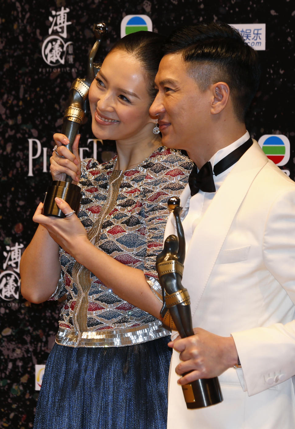 Chinese actress Zhang Ziyi, left, and actor Nick Cheung Ka-fai pose after winning the Best Actress award for her movie “The Grandmaster” and Best Actor awards for his movie “Unbeatable” of the 33rd Hong Kong Film Awards in Hong Kong Sunday, April 13, 2014. (AP Photo/Kin Cheung)