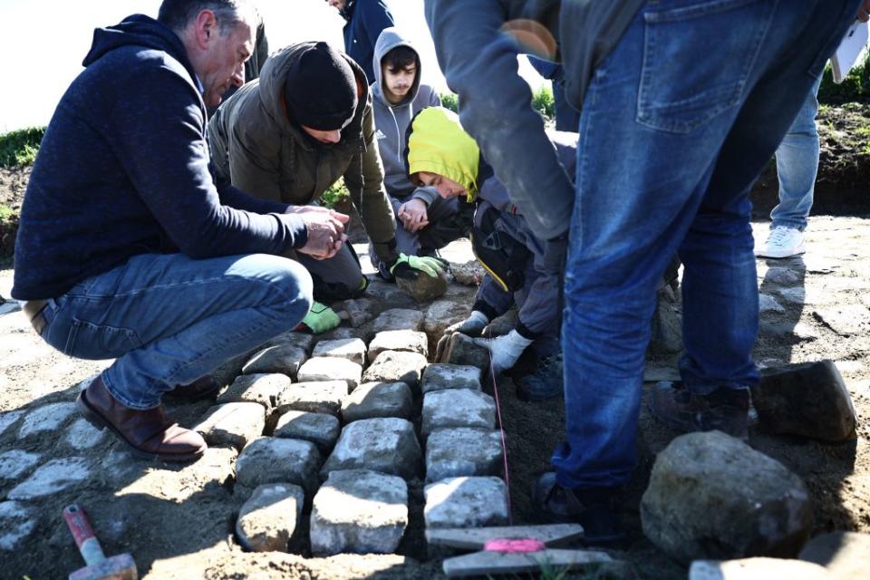 Workers repair cobblestones on the route of the ParisRoubaix cycling race in presence of race director Thierry Gouvenou L near Arenberg on April 4 2023 ahead of this weekends men and women races Photo by AnneChristine POUJOULAT  AFP Photo by ANNECHRISTINE POUJOULATAFP via Getty Images