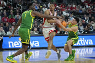 Arizona forward Keshad Johnson (16) attempts to drive through Oregon center N'Faly Dante (1) and Oregon guard Jackson Shelstad, right, during the first half of an NCAA college basketball game in the semifinal round of the Pac-12 tournament Friday, March 15, 2024, in Las Vegas. (AP Photo/John Locher)