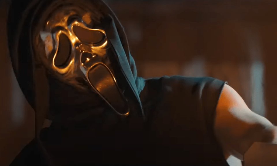 A still from Scream shows Ghostface in a silver mask with ripped sleeves looking buff