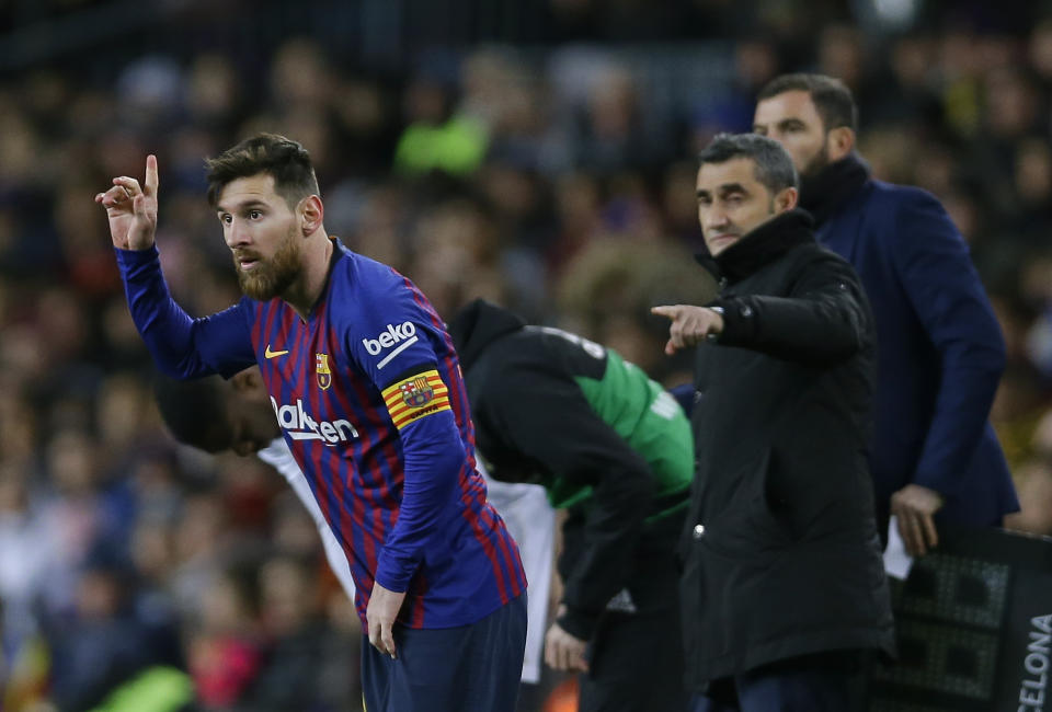 FC Barcelona's Lionel Messi, left, gestures next to his coach Ernesto Valverde during the Spanish La Liga soccer match between FC Barcelona and Valencia at the Camp Nou stadium in Barcelona, Spain, Saturday, Feb. 2, 2019. (AP Photo/Manu Fernandez)