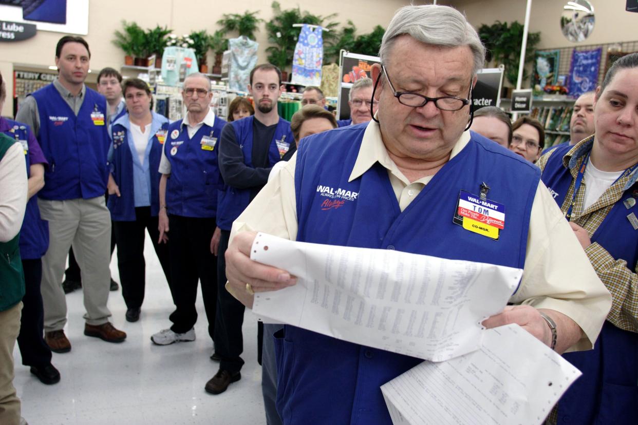 The manager of a Wal-Mart store reads the previous day sales and announces the company's latest stock value to the store's employees.